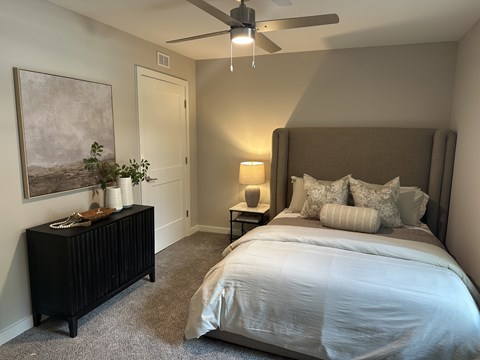 A bedroom with a large bed and a painting on the wall.