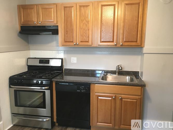 A kitchen with wooden cabinets and black appliances.
