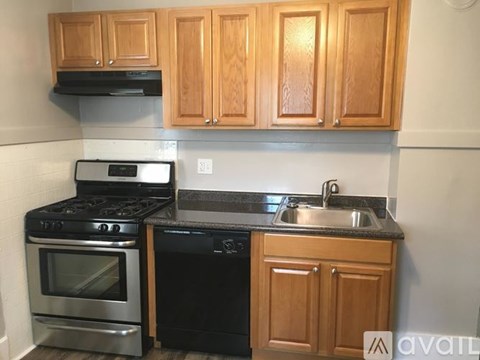 A kitchen with wooden cabinets and black appliances.