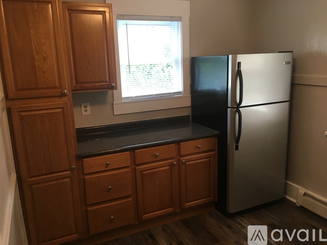 A kitchen with wooden cabinets and a black countertop.