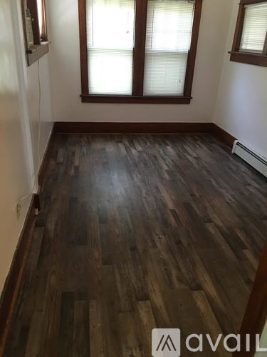A room with wooden flooring and a window.