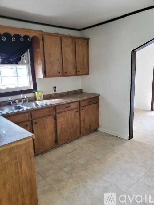 A kitchen with wooden cabinets and a tiled floor.
