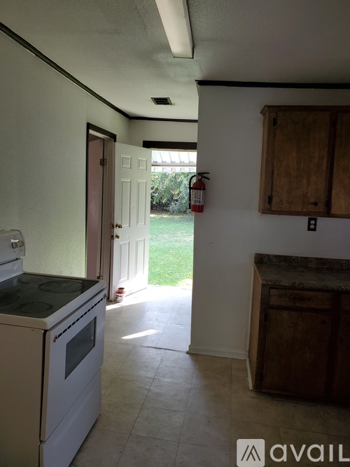 A kitchen with a stove top oven and a wooden cabinet.