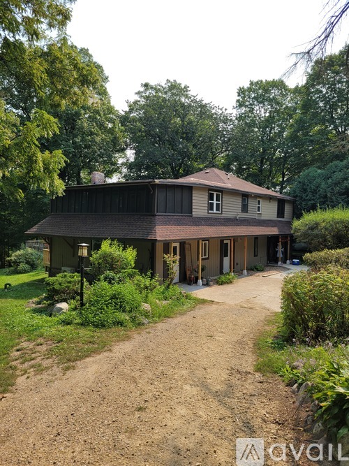 A house with a brown roof and a dirt path leading to it.