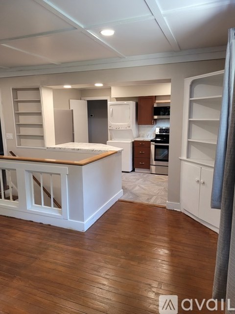 A kitchen with wooden floors and white cabinets.