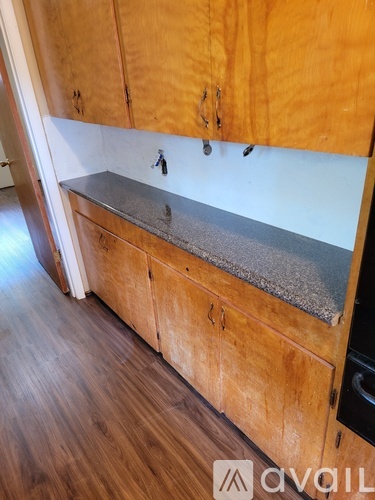 A kitchen with wooden cabinets and a granite countertop.