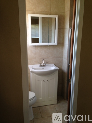A small bathroom with a toilet, sink and medicine cabinet.