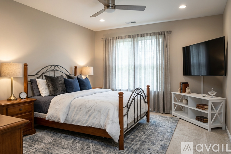 A bedroom with a bed, dresser, and mirror.