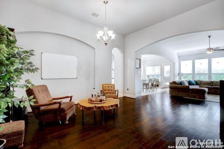 A living room with a brown sofa, a wooden coffee table, and a large painting on the wall.