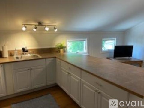 A kitchen with white cabinets and a wooden countertop.