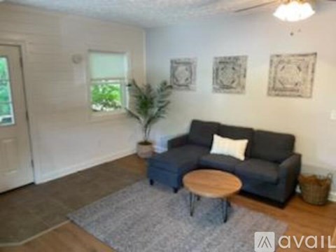 A living room with a grey couch and a wooden coffee table.
