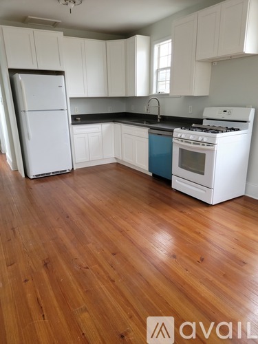 A kitchen with white cabinets and a white fridge.