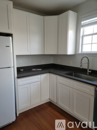 A kitchen with white cabinets and a white refrigerator.