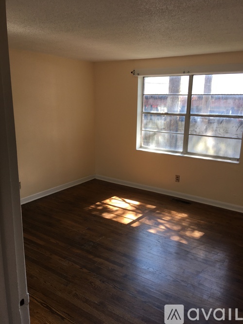 A room with a window and wooden flooring.