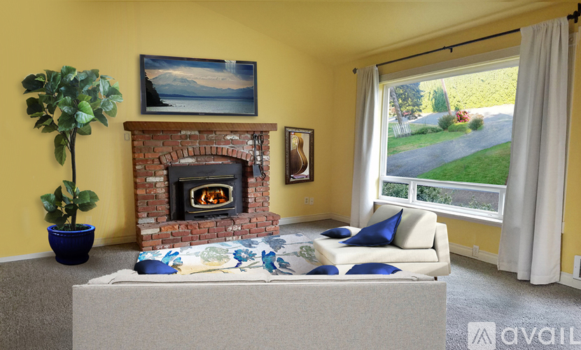 A living room with a fireplace and a painting on the wall.