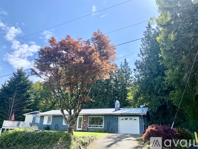 A house with a tree in front of it is for sale.