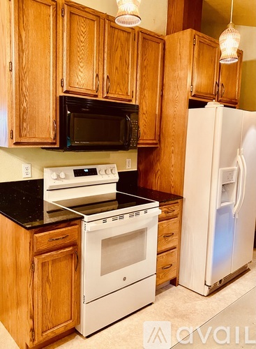A kitchen with wooden cabinets and a white refrigerator.