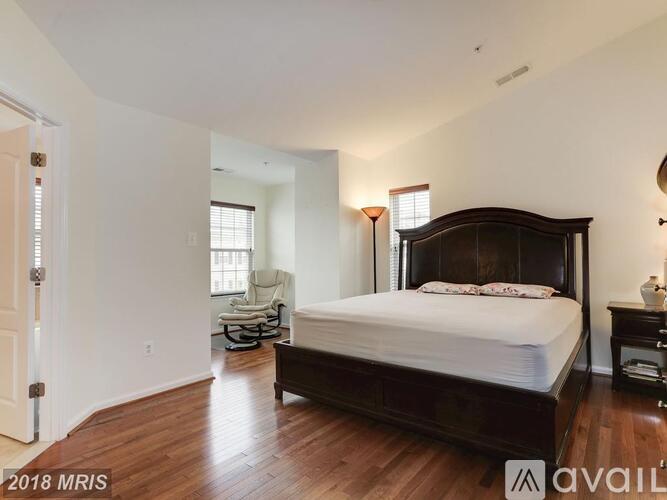 A bedroom with a large bed and a chair.