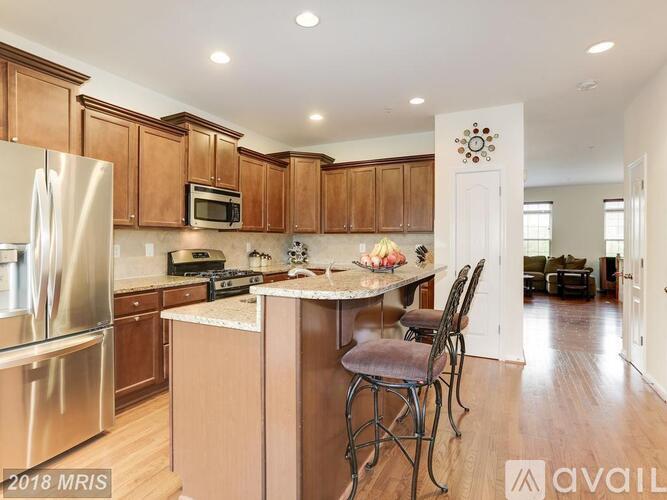 A kitchen with wooden cabinets and a stainless steel refrigerator.