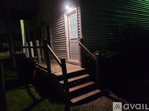 A house entrance with a lit door and steps.