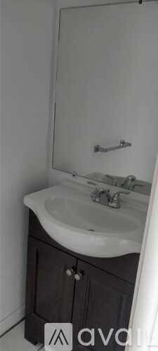 A bathroom with a white sink and a mirror above it.