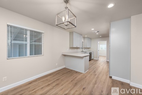 A kitchen with white cabinets and a wooden floor.
