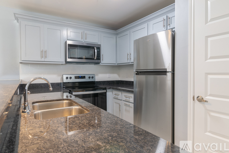 A kitchen with a granite countertop and stainless steel appliances.