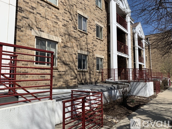 A brick building with a red railing in front.