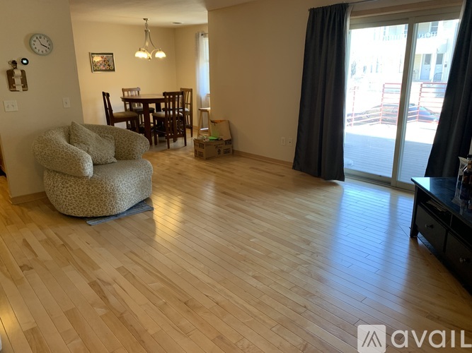 A living room with a wooden floor and a dining table.