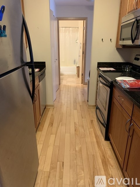 A kitchen with a refrigerator on the left and a microwave on the right.