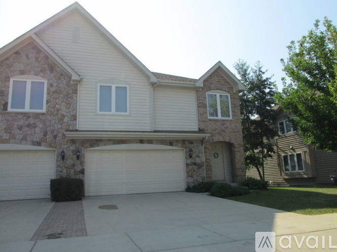 A house with a stone wall and a garage door.