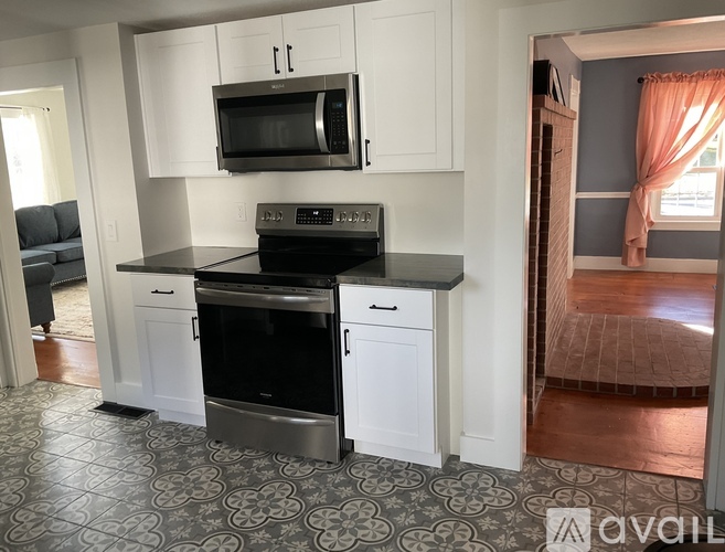 A kitchen with a black stove top oven and a black microwave above a black counter top.