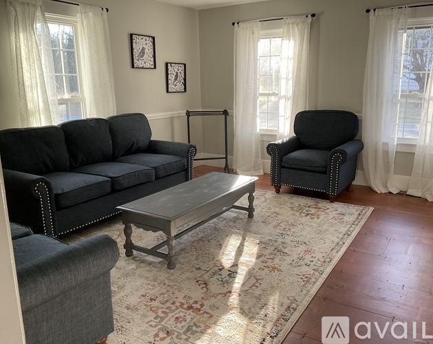 A living room with a grey couch, a black chair, and a coffee table.