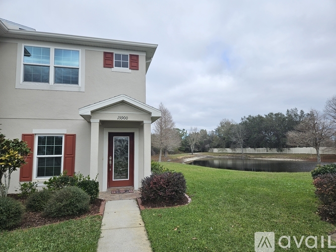 A house with a red door and a small pond in the backyard.