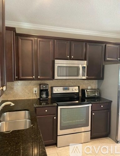 A kitchen with brown cabinets and stainless steel appliances.