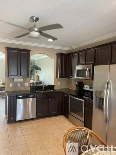 A kitchen with a refrigerator, stove, and microwave.