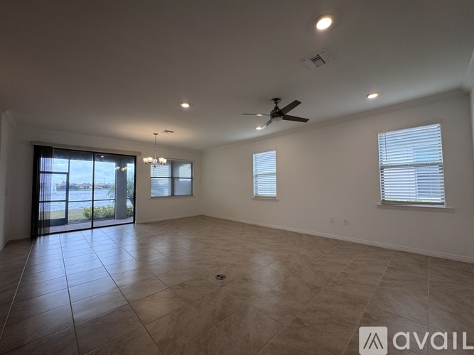A spacious room with a ceiling fan and large windows.