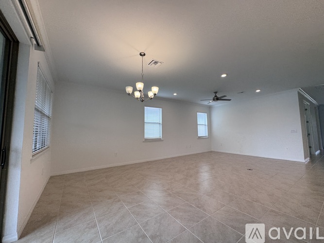 A spacious room with tiled flooring and a ceiling fan.