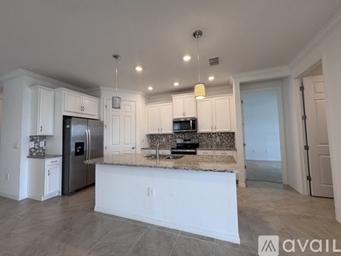 A kitchen with white cabinets and a granite countertop.
