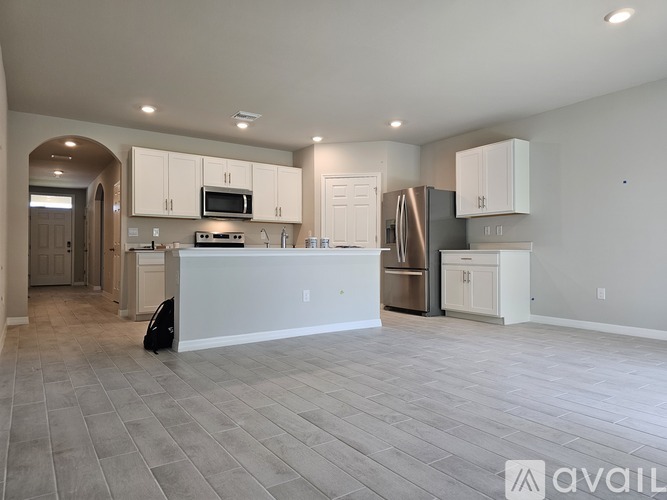 A spacious kitchen with white cabinets and a central island.