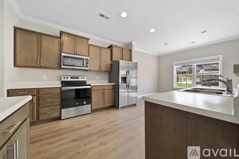 A kitchen with wooden cabinets and a refrigerator.