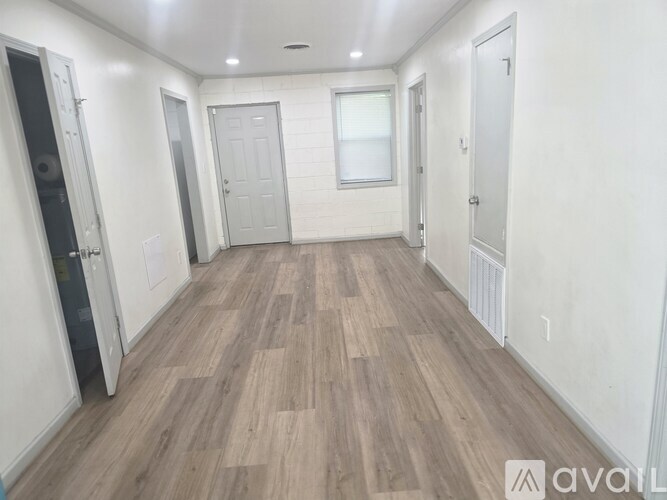 A room with wooden flooring and white walls.