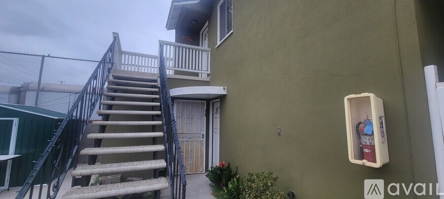 A staircase with a metal railing leads up to a balcony.