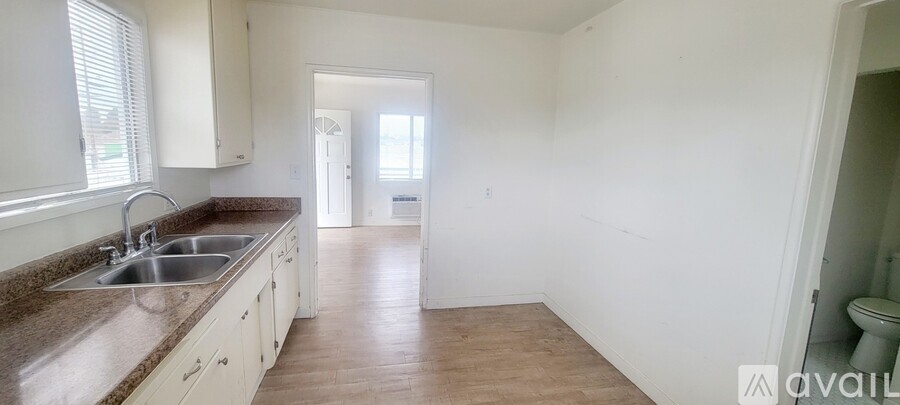 A kitchen with white cabinets and a brown countertop.