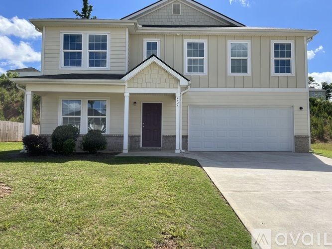 A two-story house with a garage is available for sale.