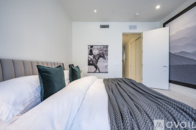 A bedroom with a large bed and a painting of a horse on the wall.