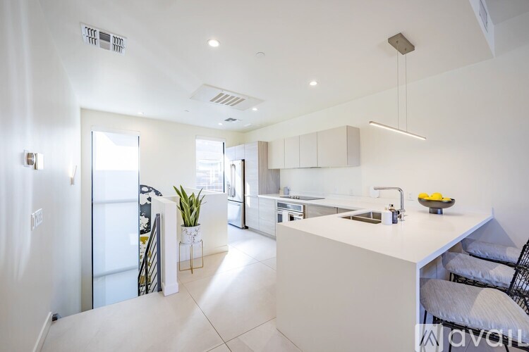 A modern kitchen with white cabinets and a white island.