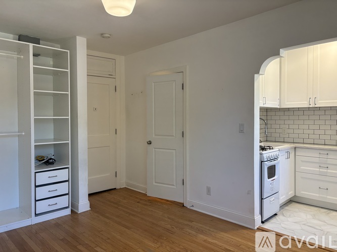 A kitchen with white cabinets and a wooden floor.