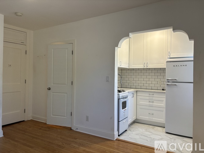 A kitchen with white appliances and cabinets.