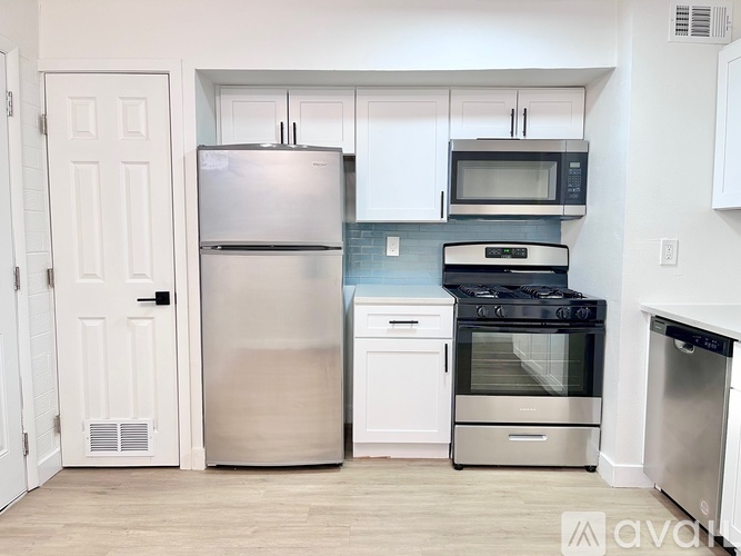 A kitchen with white cabinets and stainless steel appliances.